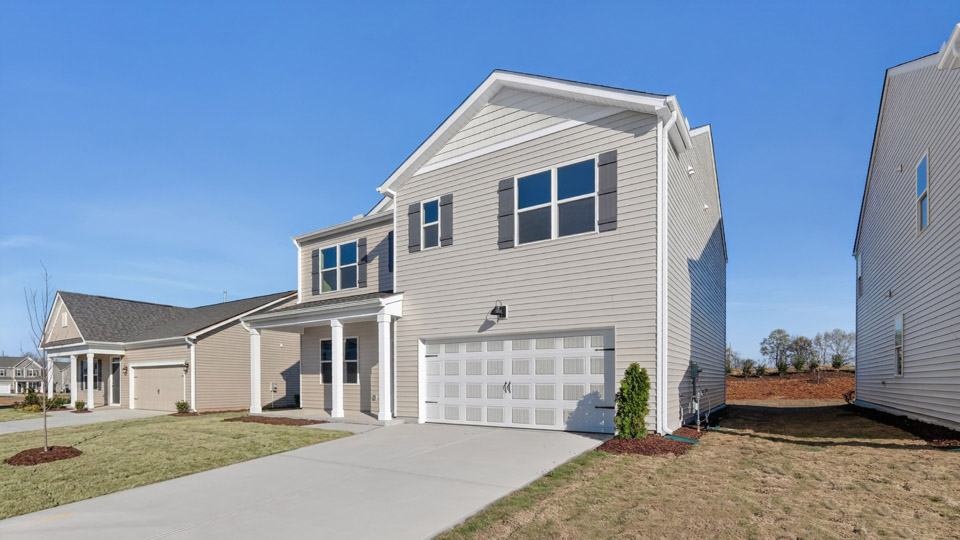 Two story home with white colored siding with a two car garage
