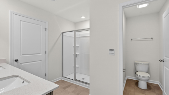 bathroom with walkin glass door shower and water closet