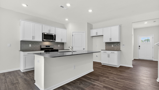 kitchen with island quartz countertops and white cabinets