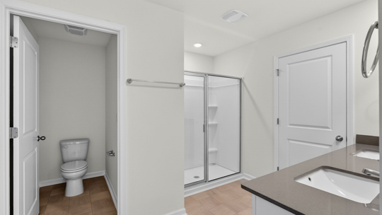 bathroom with water closet walkin shower and dual vanity