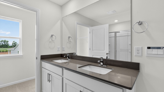bathroom with dual vanity and quartz countertops