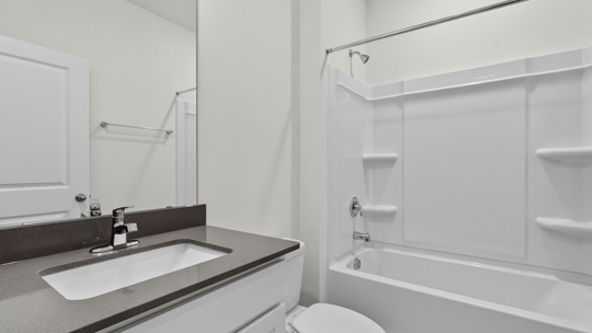 bathroom with quartz countertops and tub shower combo