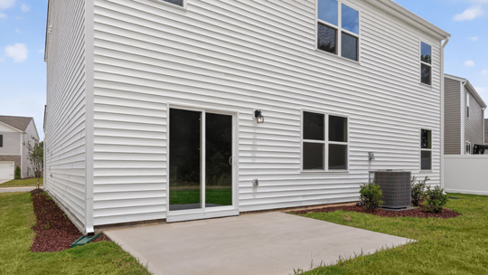 back of home with concrete patio