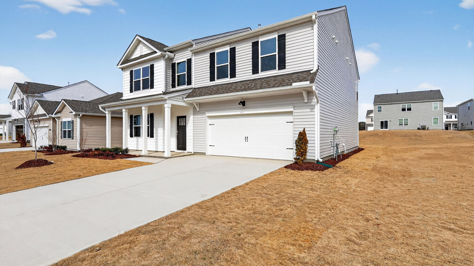 Two story home with white colored siding with a two car garage
