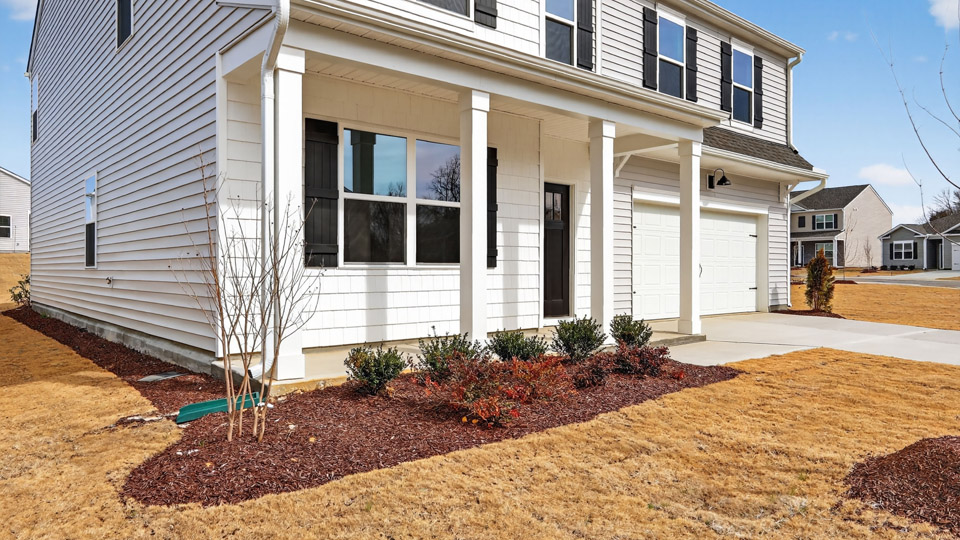 Two story home with white colored siding with a two car garage