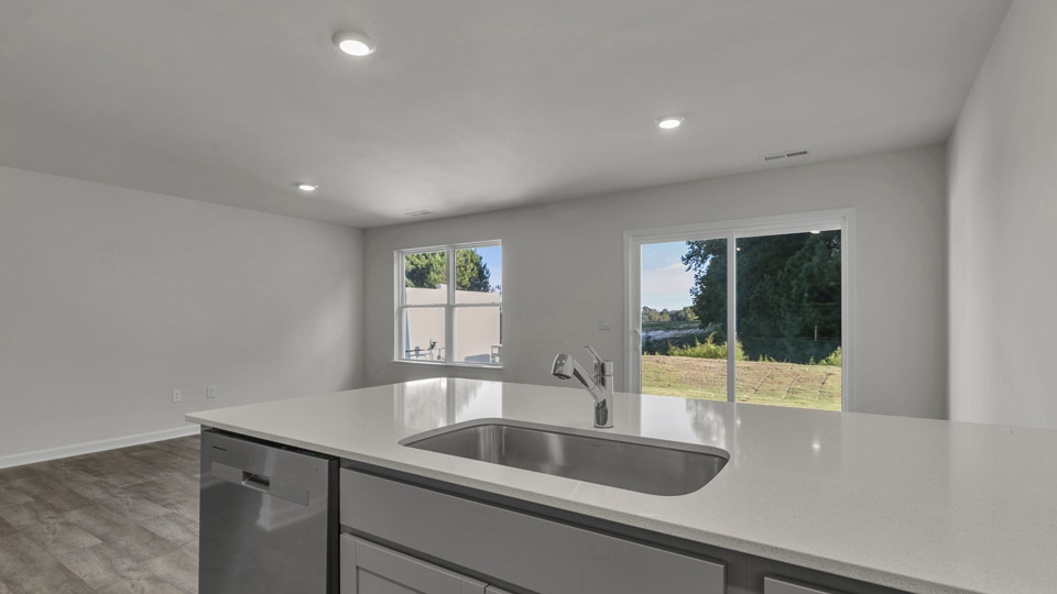 kitchen with quartz counters, kitchen peninsula, pantry, stainless steel appliances