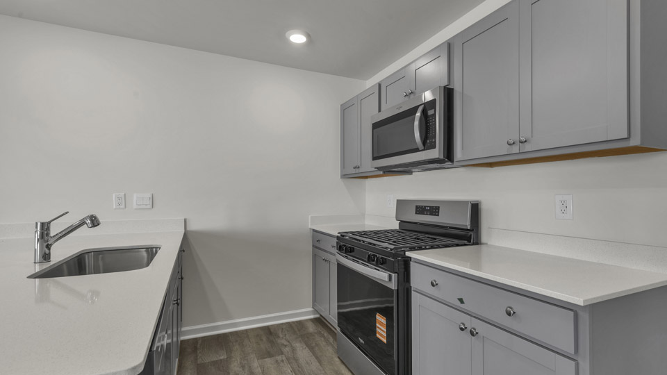 kitchen with quartz counters, kitchen peninsula, pantry, stainless steel appliances