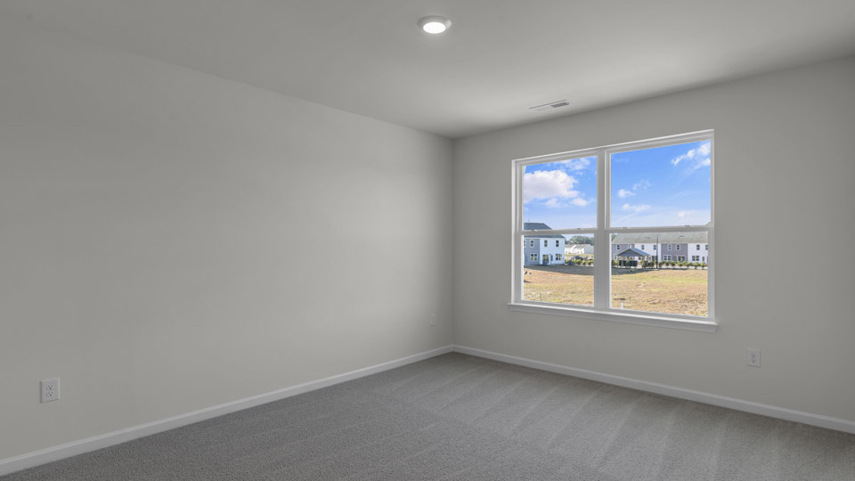 primary bedroom with two windows and carpeting, attached bath