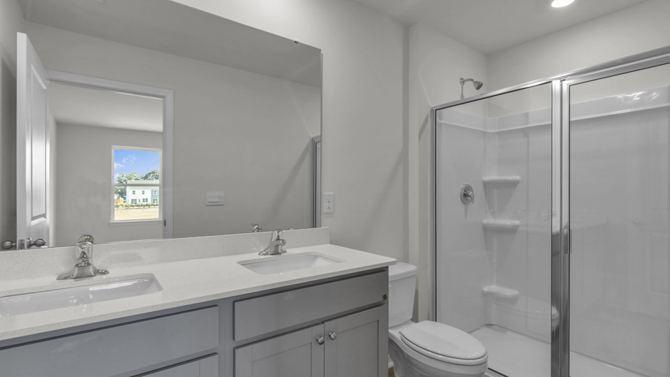 primary bathroom with walk in shower and dual vanity sinks