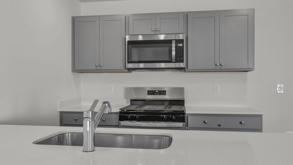 kitchen with quartz counters, kitchen peninsula, pantry, stainless steel appliances