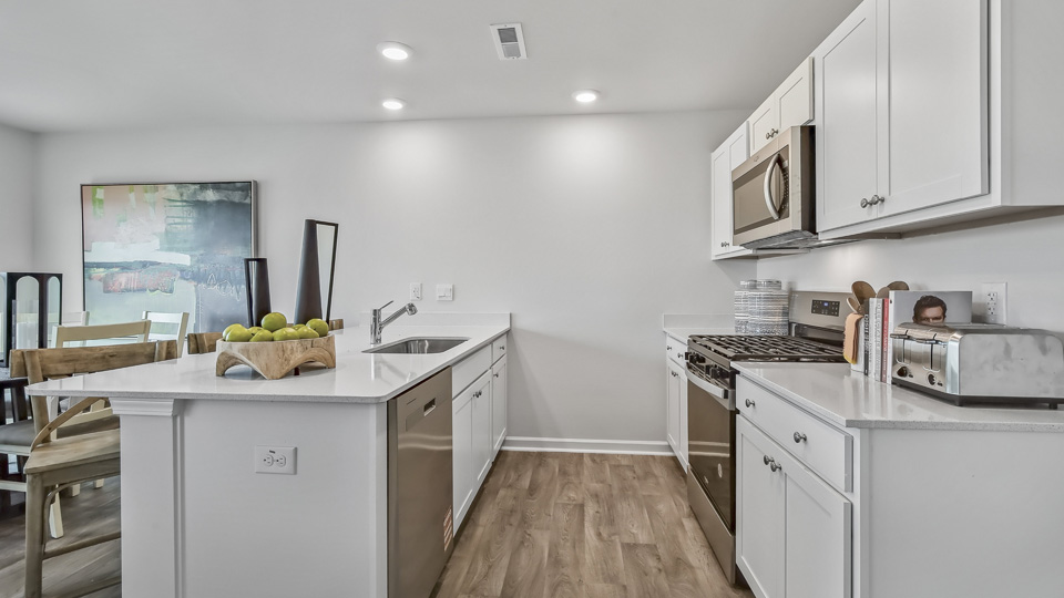 kitchen with quartz counters, kitchen island, pantry, stainless steel appliances