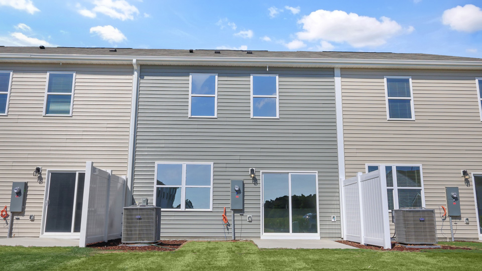 back of home with concrete patio and partition wall