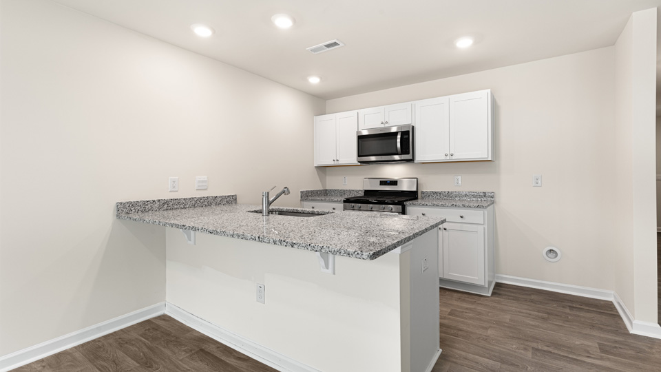 kitchen with quartz counters, kitchen island, pantry, stainless steel appliances