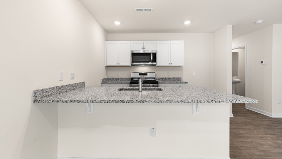 kitchen with quartz counters, kitchen island, pantry, stainless steel appliances