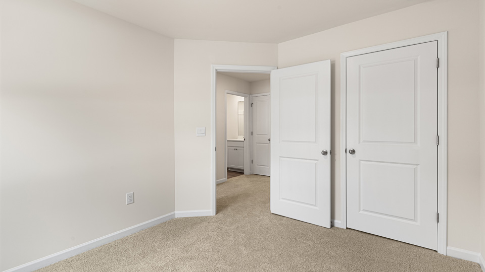secondary bedroom with window and closet, carpeting