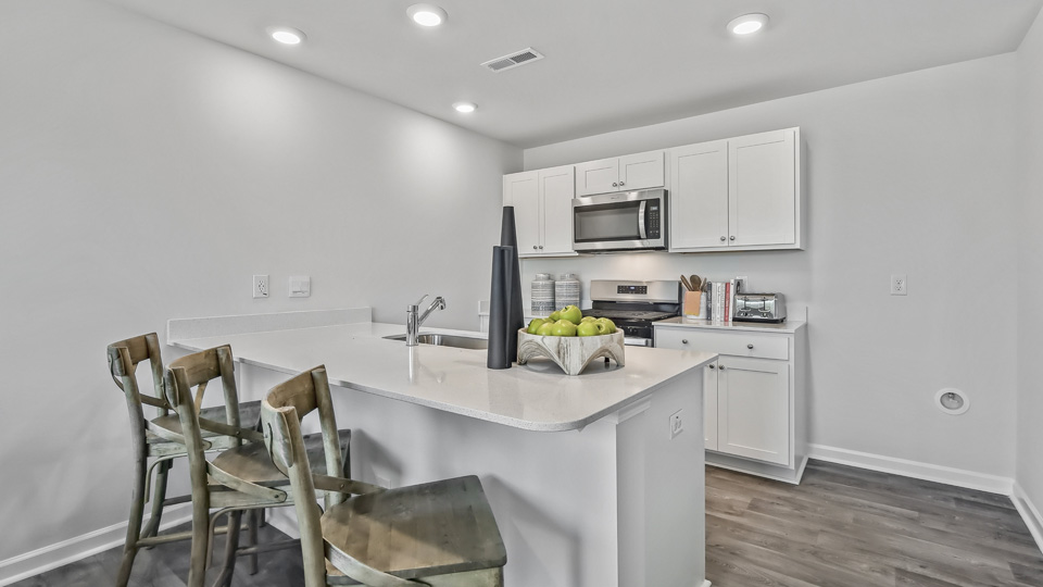 kitchen with quartz counters, kitchen island, pantry, stainless steel appliances