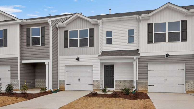 Two story town home with white and gray siding and a garage.