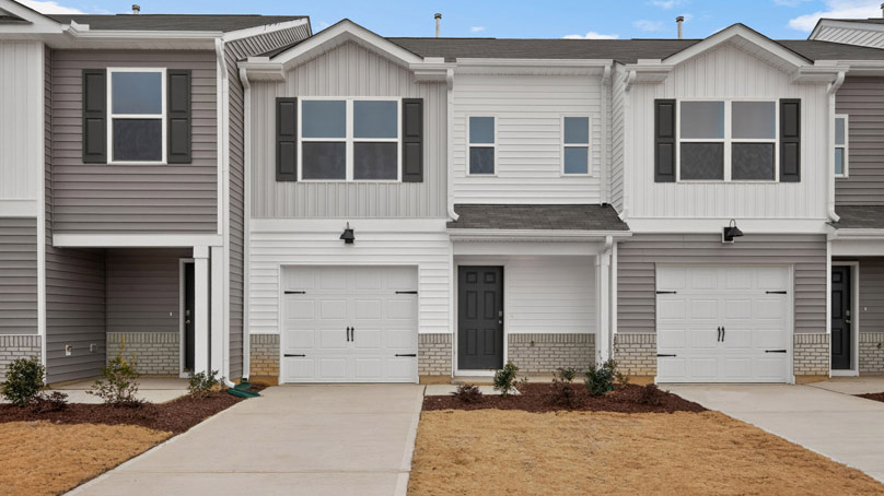 Two story town home with white and gray siding and a garage.