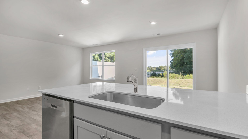 kitchen with quartz counters, kitchen peninsula, pantry, stainless steel appliances