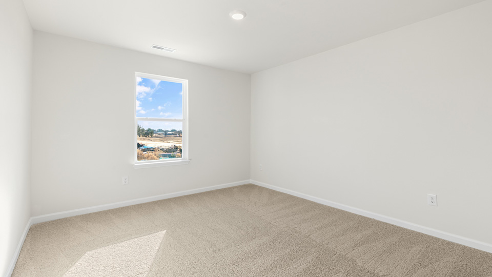 primary bedroom with two windows and carpeting, attached bath