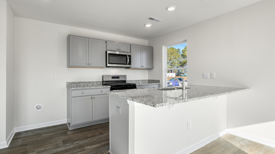 kitchen with quartz counters, kitchen island, pantry, stainless steel appliances