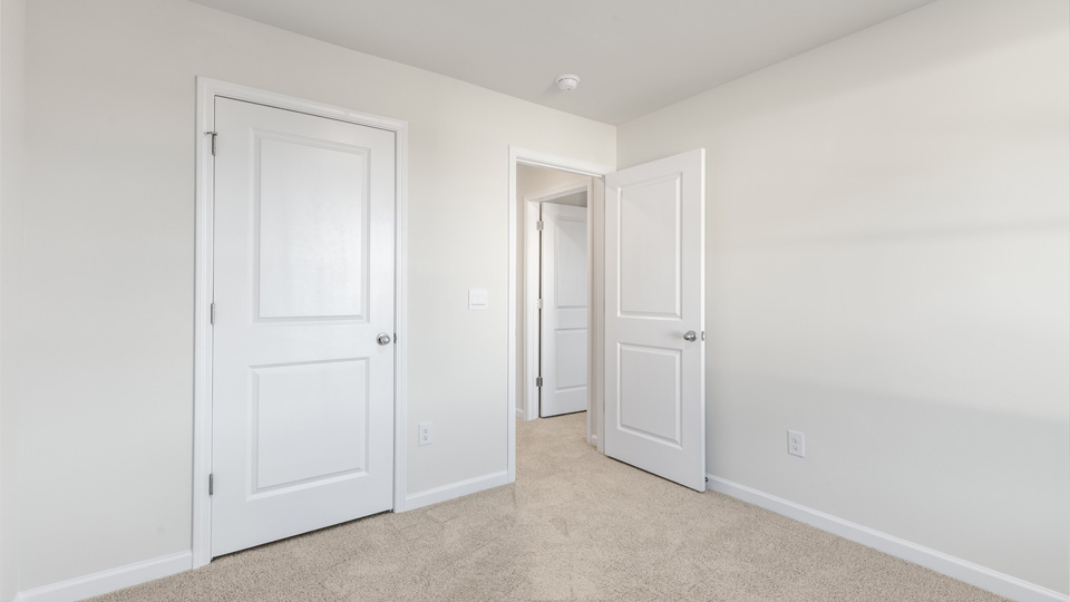 secondary bedroom with window and closet, carpeting