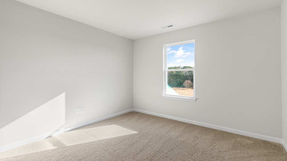 primary bedroom with two windows and carpeting, attached bath