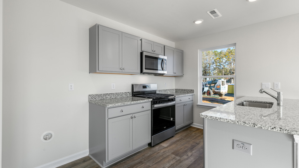 kitchen with quartz counters, kitchen island, pantry, stainless steel appliances