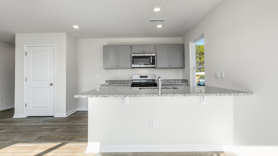 kitchen with quartz counters, kitchen island, pantry, stainless steel appliances