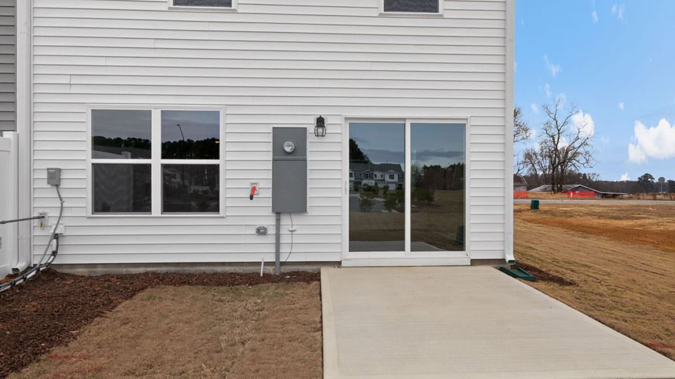 Two story home with white siding and back patio