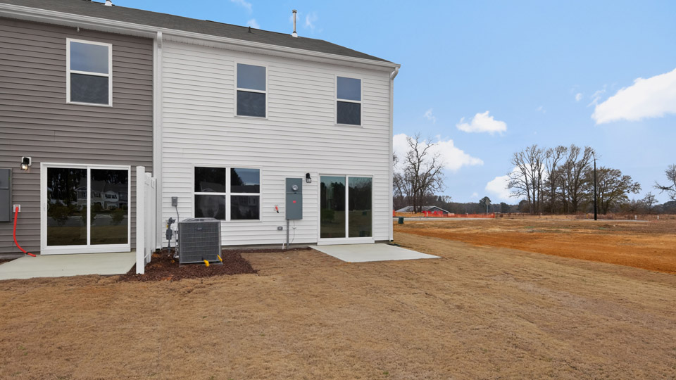 Two story home with white siding and back patio