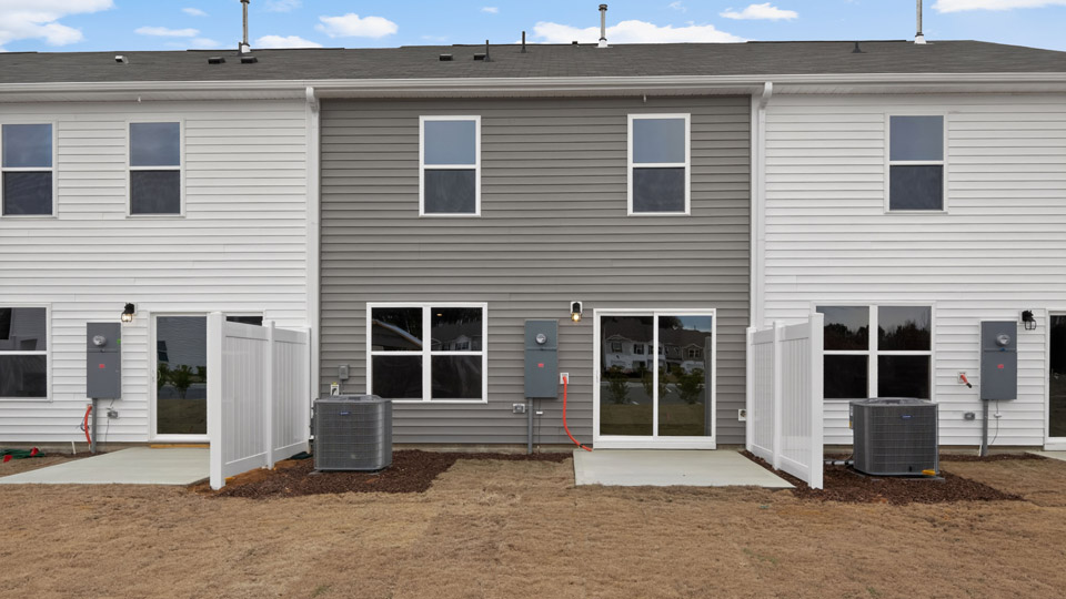 Two story home with gray siding and back patio