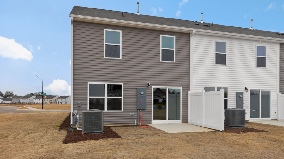 Two story home with gray siding and two-car garage.