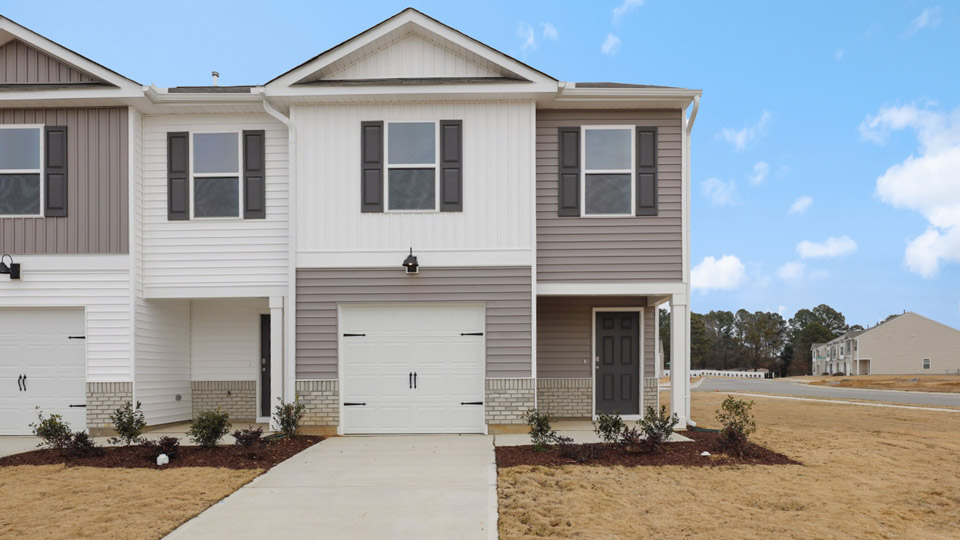 Two story home with white and gray siding and two-car garage.