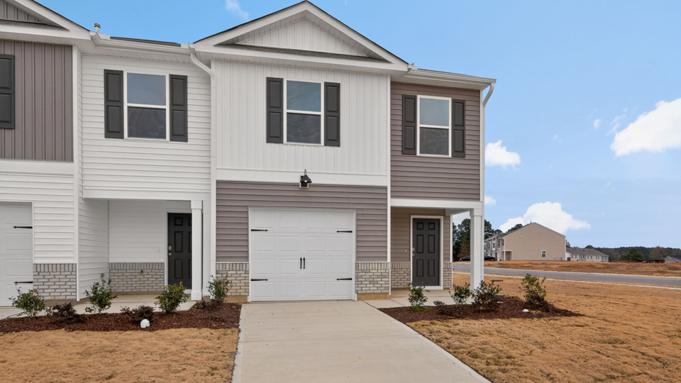 Two story home with white and gray siding and two-car garage.