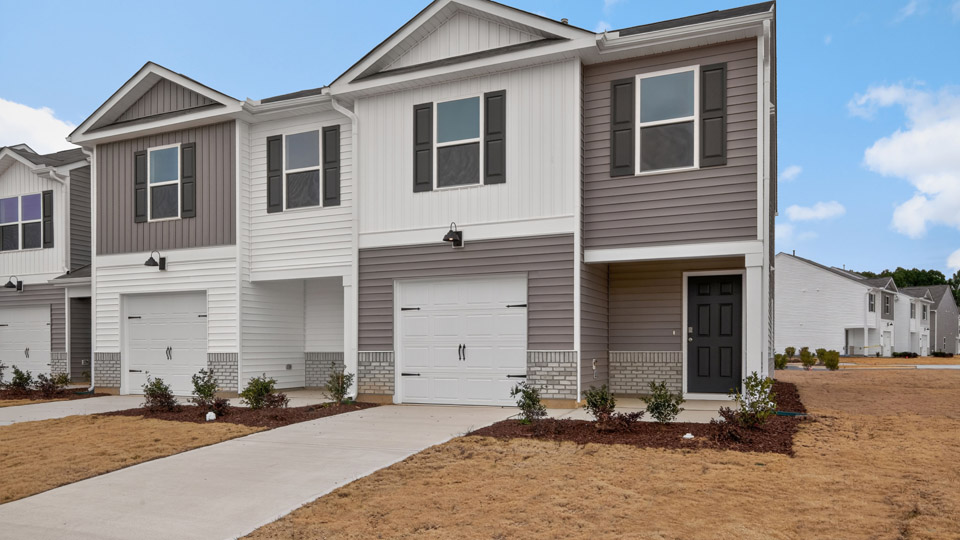 Two story home with white and gray siding and two-car garage.