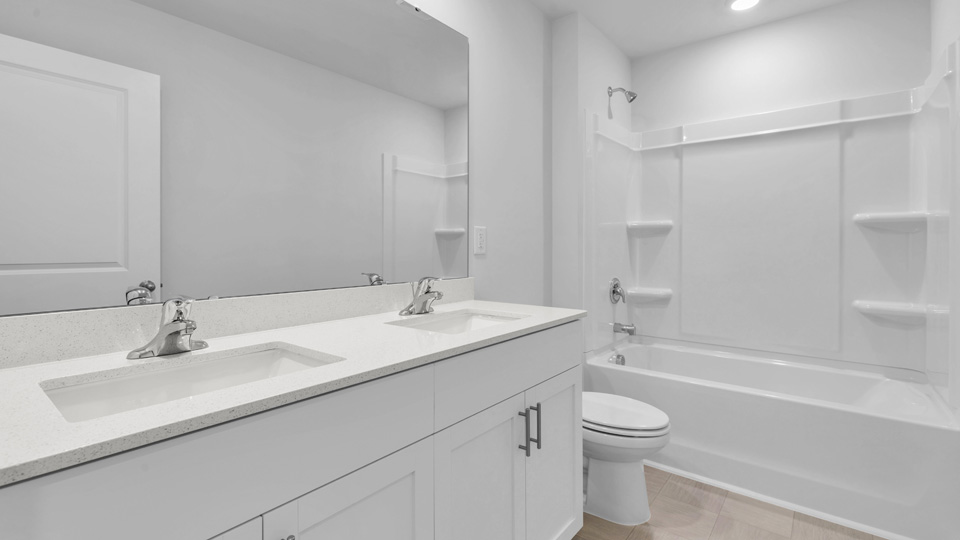 bathroom with tub shower combo white cabinets and quartz countertops