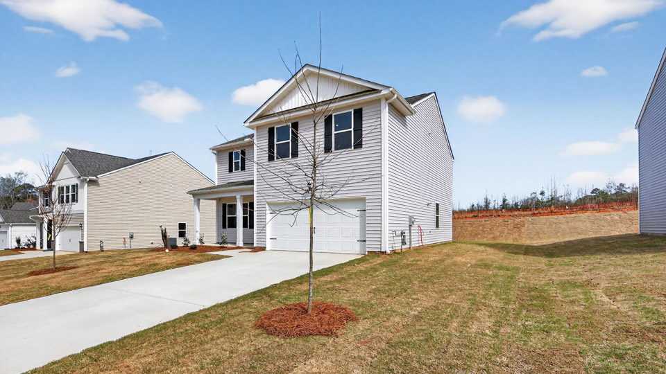 Two story home with white colored siding with a two car garage