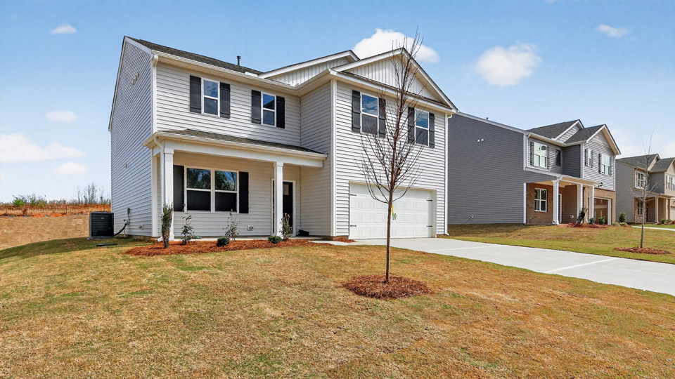Two story home with white colored siding with a two car garage