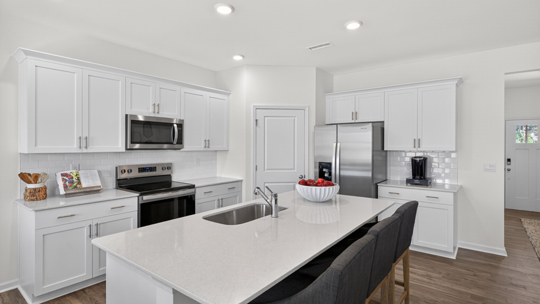 kitchen with large island white cabinets and quartz countertops