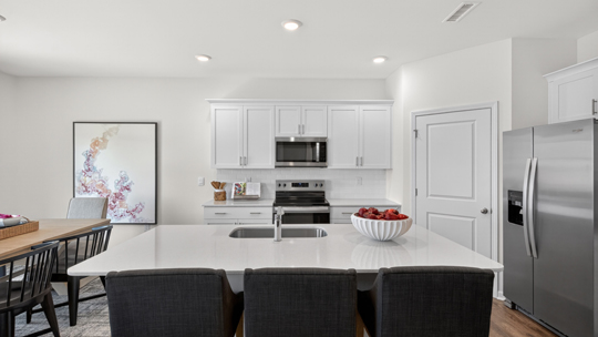 kitchen with large island white cabinets and quartz countertops