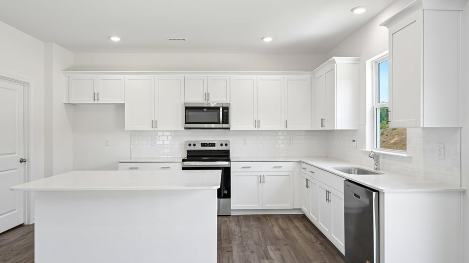 kitchen with quartz counters, kitchen island, pantry, stainless steel appliances