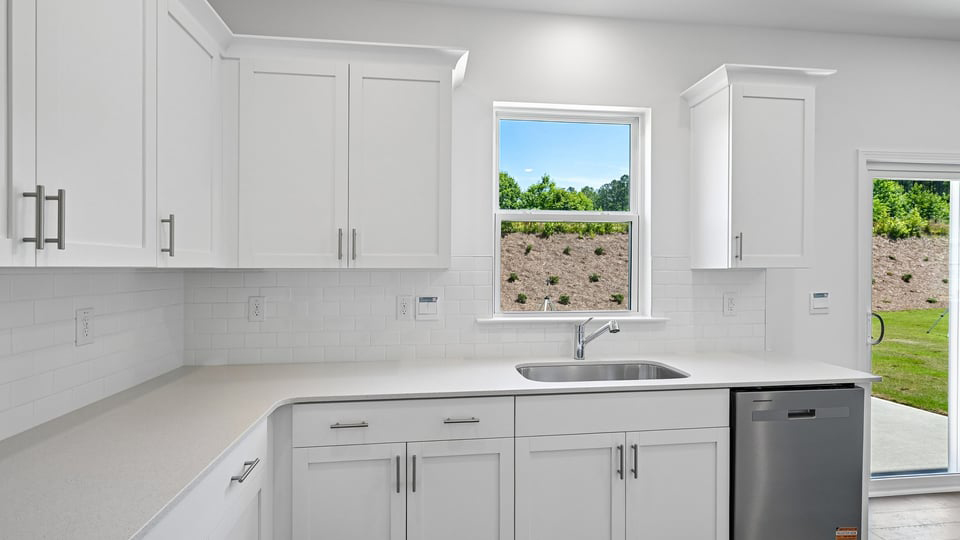 kitchen with quartz counters, kitchen island, pantry, stainless steel appliances