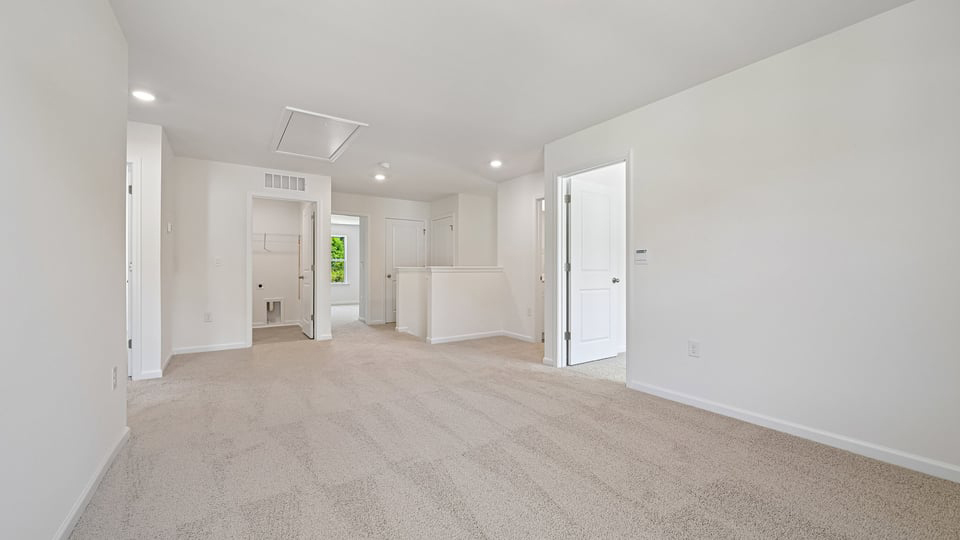 upstairs loft area with large windows and carpeting