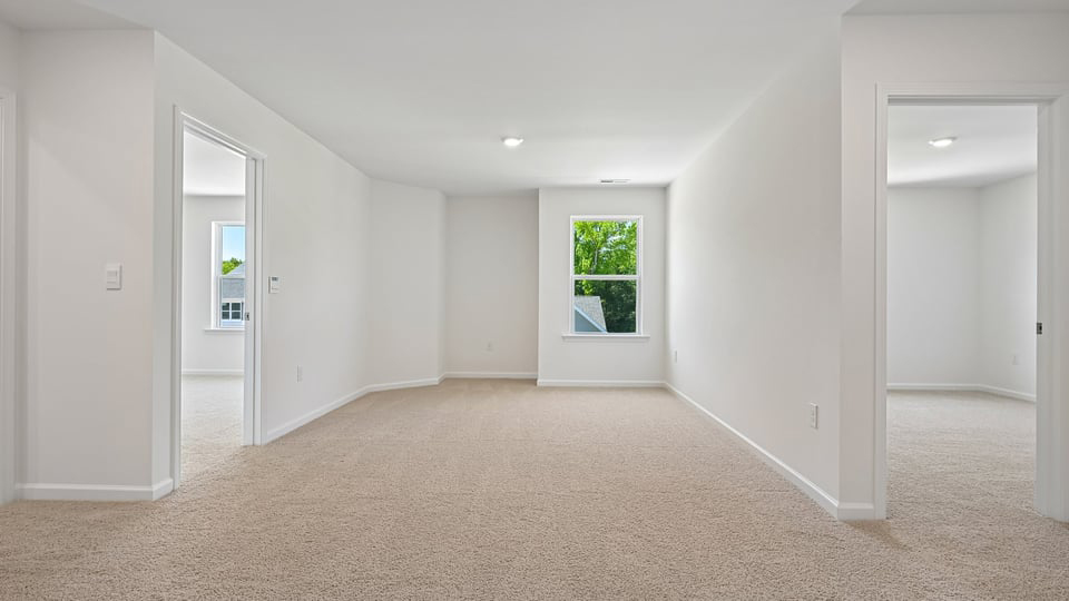 upstairs loft area with large windows and carpeting