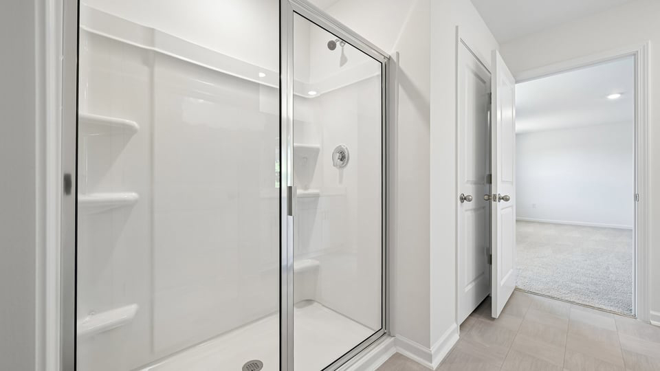 primary bathroom with walk in shower and dual vanity sinks