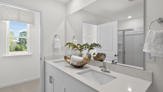 bathroom with white cabinets and quartz countertops