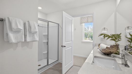 bathroom with white cabinets and quartz countertops