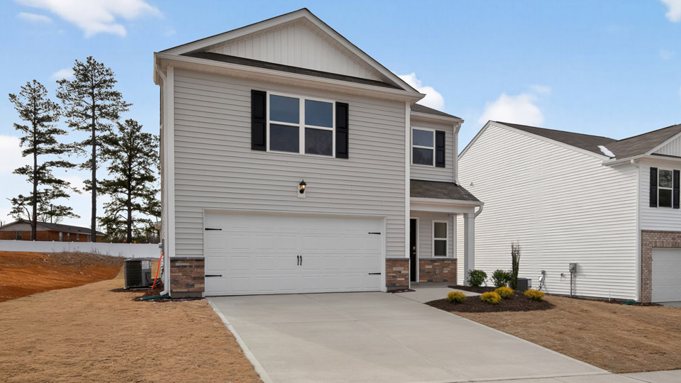 Two story home with white colored siding with a two car garage