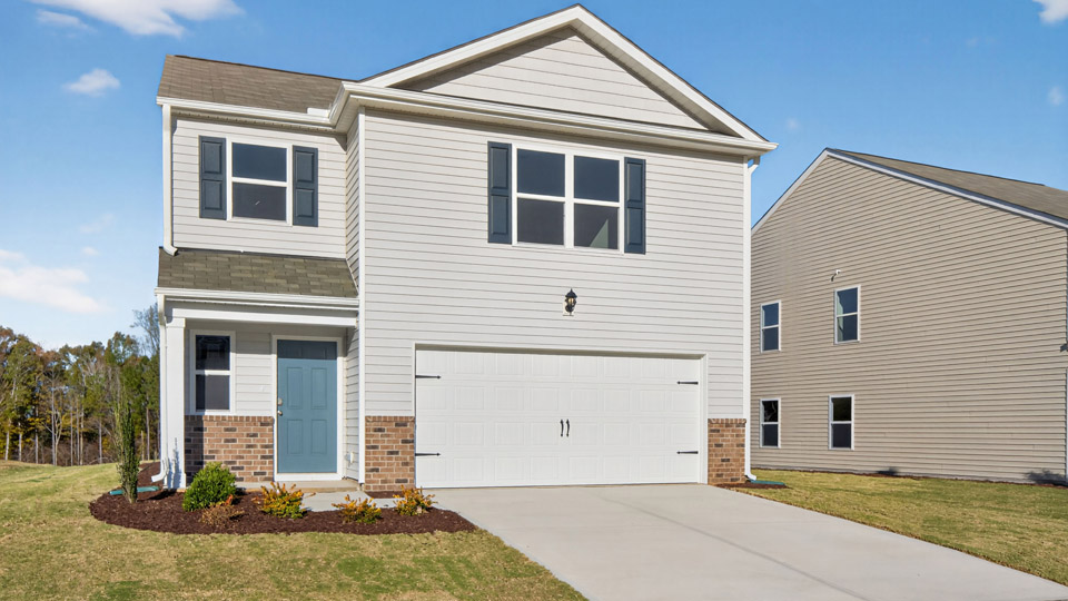 Two story home with white siding and two-car garage.
